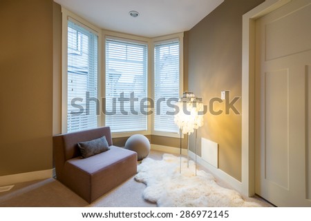 Fragment of a modern luxury master bedroom with a large chair , lamp, and a sheepskin rug. Interior design.