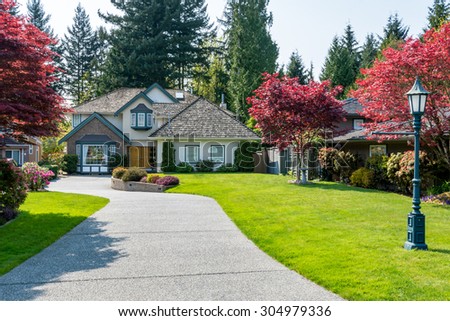 Cozy house with beautiful landscaping on a sunny day. Home exterior.