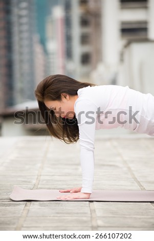 Asia Girl on Yoga Position on a Rooftop in Hong Kong Island