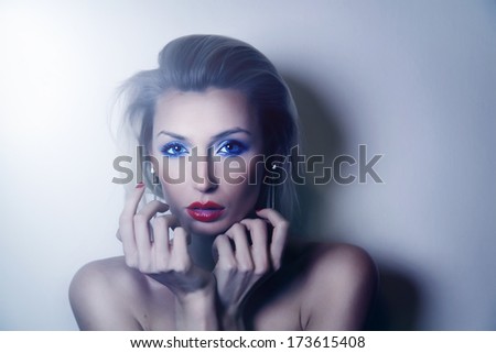 Beautiful elegant blonde woman posing, looking at camera. Sexy lady with evening makeup.