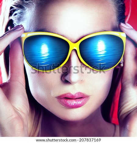 Closeup portrait of beautiful blonde woman wearing fashionable sunglasses.
