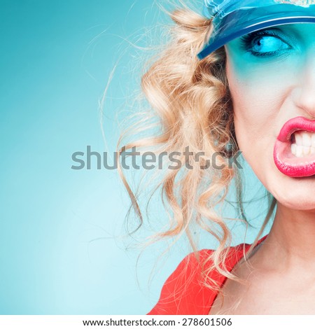 Portrait of beautiful blonde woman making funny face. Blue background.