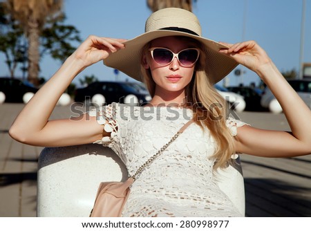 Summer portrait of blonde beautiful woman. Girl posing in fashionable sunglasses and hat.