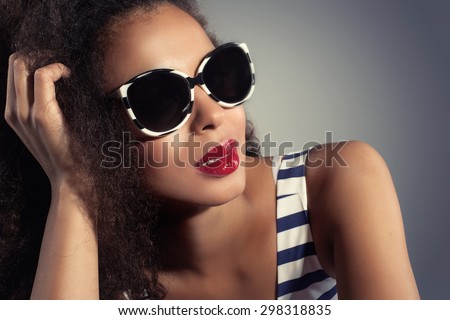 Closeup beauty portrait of young attractive woman wearing fashionable sunglasses. African american girl with red lips.