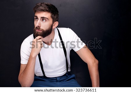 Portrait of handsome young man with beard. Fashion photo. Dark background. Studio shot.