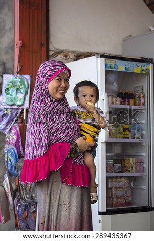 PENIDA ISLAND, INDONESIA - JUNE 22.2015:woman Muslim with chidren at the market, village Toyopakeh, Nusa Penida June 22. 2015 Indonesia