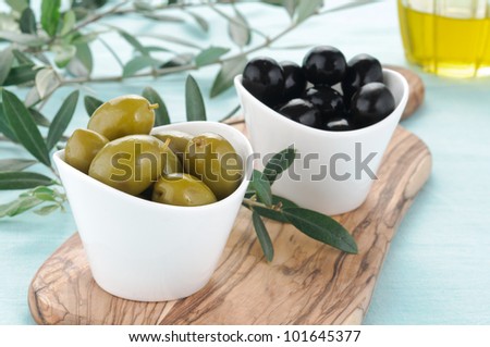 Green and black olives in white bowl