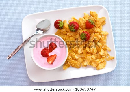 Breakfast with yogurt, strawberry and corn flakes
