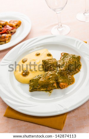 Fish in savory sauce with polenta