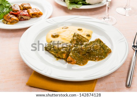 Fish in savory sauce with polenta