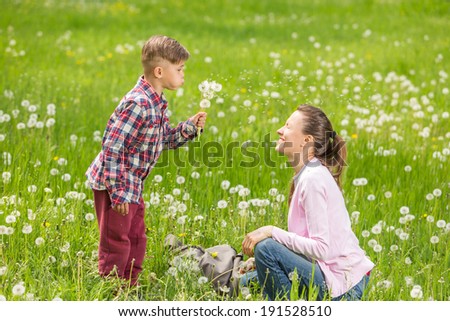Enjoying life together concept. Happy mother and son having fun outdoors on a sunny summer day