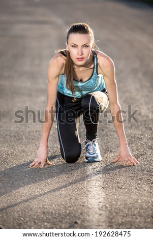 Running woman. Female sprinter waiting for the start on road. soft backlight