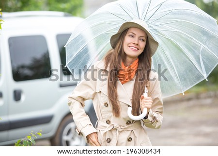 Young happy woman with umbrella in the street walking