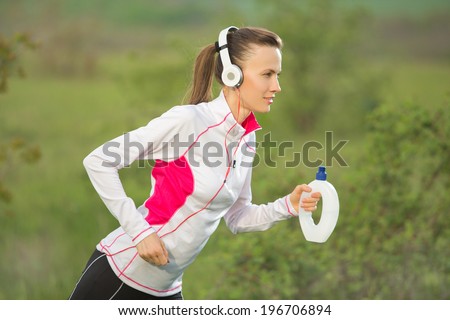 Running woman. Young woman jogging outdoors on green nature background. Sport woman starting running
