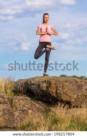 Young woman practicing yoga outdoor with closed eyes