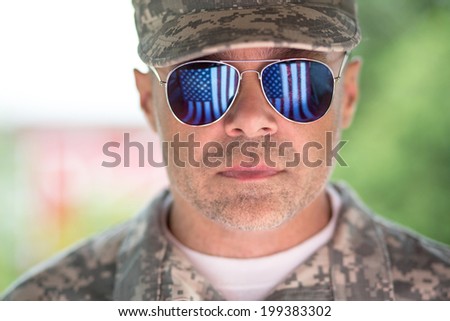 Proud us army soldier with american flag in sunglasses reflection. focus on glasses
