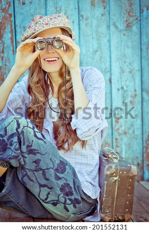 Happy traveler looking in binoculars happy smiling. toned vintage style. focus on face