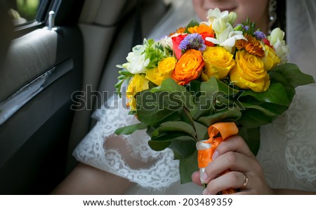 Close-up shot of a wedding flowers in bride hand in a car in the evening. focus on flowers