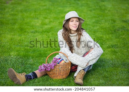 Happy people - free woman enjoying nature sitting on grass happy smiling. soft daylight