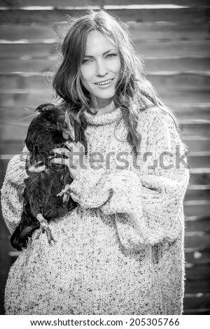 Black and white portrait of beauty fashion woman with a hen. focus on woman
