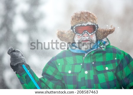Man traveler hiking in winter in stormy snow weather. Man covered by snow in heavy snowstorm. Active healthy lifestyle concept