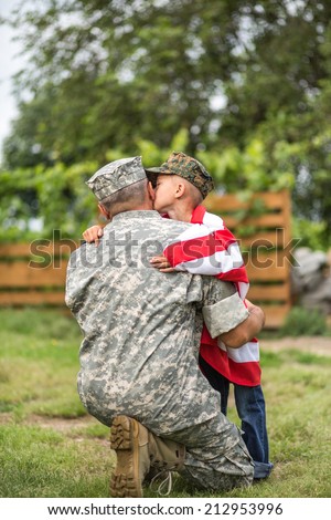 Beautiful modern american family. Father wearing military uniform hugs his son. focus on father