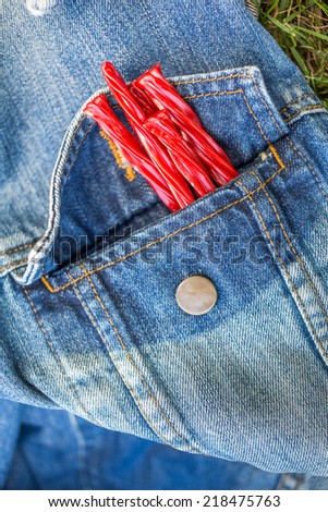 Bright Red Licorice Candy shaped like a twisted rope in a denim jacket