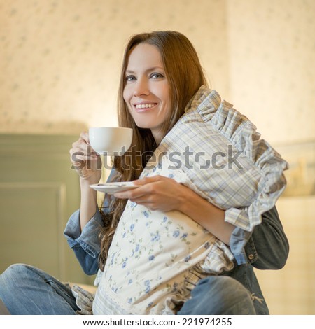Evening tea. Beautiful girl drinking tea or coffee in the evening in her bedroom