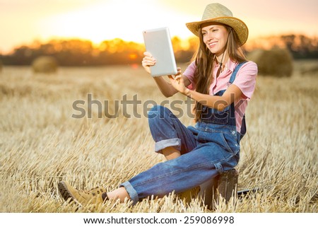 woman using tablet pc outdoor over sunset. soft evening light, glow sun