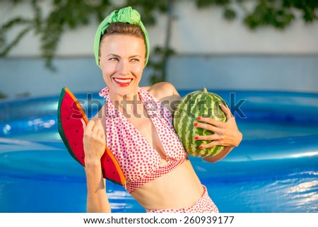 Beautiful woman relaxing in swimming pool eating watermelon