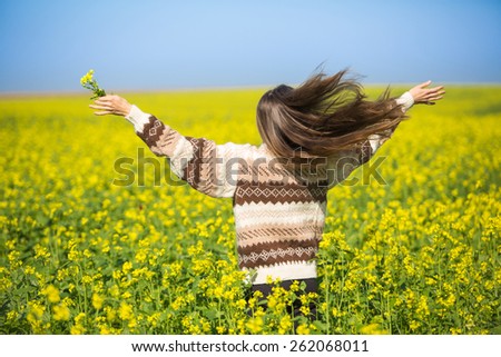 Freedom woman in free happiness bliss on yellow field with outstretched hands and flying hair. motion