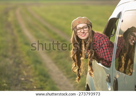 Freedom car travel concept - woman relaxing out of window in a car. Girl relaxing enjoying free holidays road trip