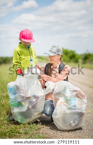 Family picking up trash, focus on hands