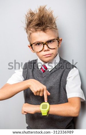 Photo of adorable young happy boy pointing to watches, hurry up concept
