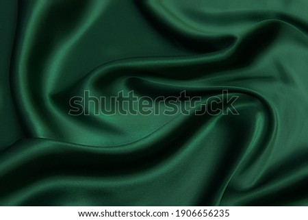 Texture, background, pattern. Texture of green silk fabric. Beautiful emerald green soft silk fabric. Stock foto © 