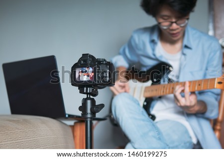 Similar – Image, Stock Photo Young man recording himself while playing guitar and singing to share the video in social media. Musician recording a music video at home.