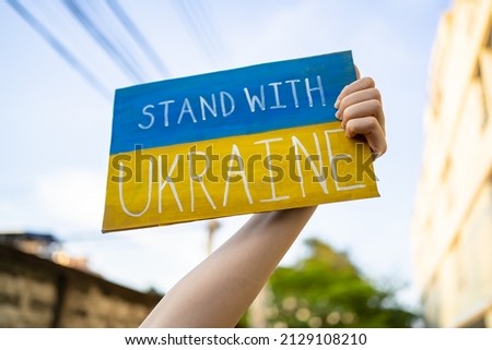 Demonstrator holding 'Stand with Ukraine' placard 商業照片 © 