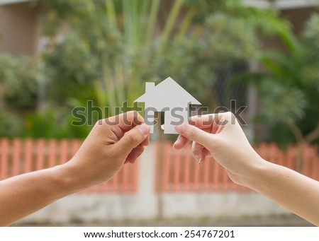 Loan concept. Young couple holding a white miniature house