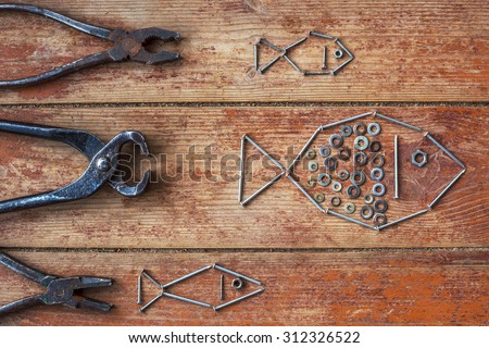 Old pliers and nails, laid out in the form of fish.Creation during repair work