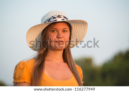 pretty girl wearing orange t-shirt and white hat