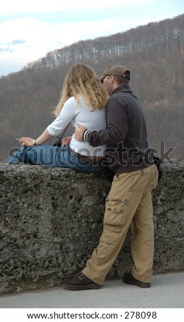 A man shows the woman landscape on old wall