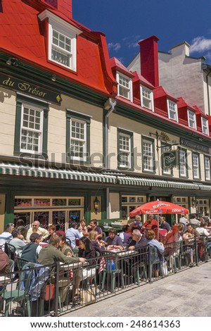 QUEBEC CITY, QUEBEC, CANADA - MAY 30, 2004: People eat and drink at outdoor tables in front of the Auberge du Tresor hotel and restaurant, in Old Quebec.