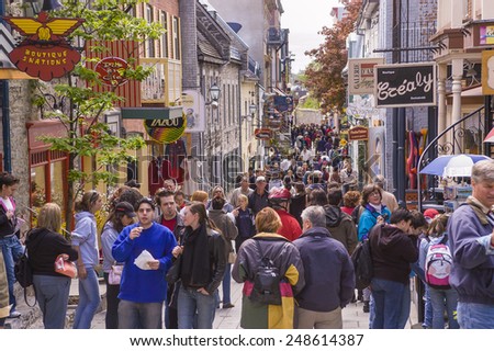 QUEBEC CITY, QUEBEC, CANADA - MAY 29, 2004:  Tourism on Petit Champlain Street, in Old Quebec City. People walk along the narrow street shopping for souvenirs.