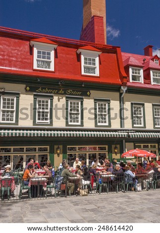 QUEBEC CITY, QUEBEC, CANADA - MAY 30, 2004: People eat and drink at outdoor tables in front of the Auberge du Tresor hotel and restaurant, in Old Quebec.