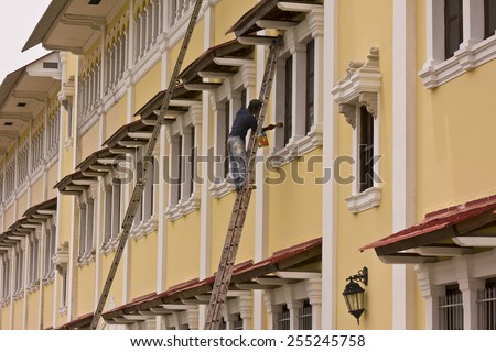 PANAMA CITY, PANAMA - AUGUST 10, 2009: Man painting window, Casco Viejo, historic city center.