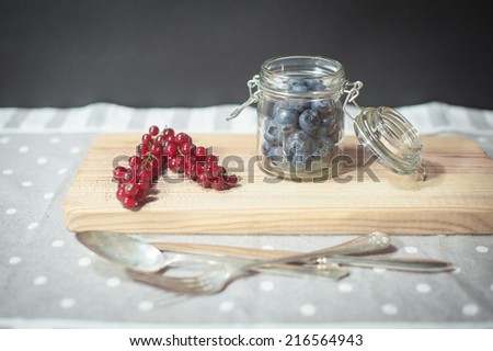 Forest fruits on a table with vintage cutlery.