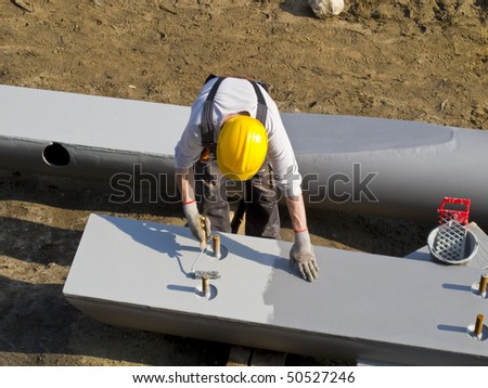 man with roller painting bridge construction