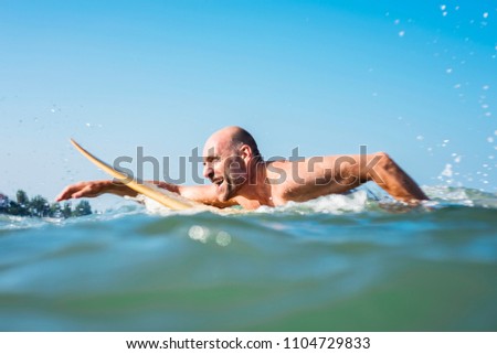 Similar – Image, Stock Photo Man swimming on surfboard in sea