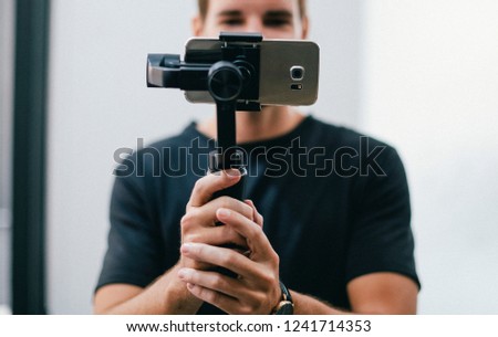 Similar – Image, Stock Photo Man filming a vlog with camera in the city