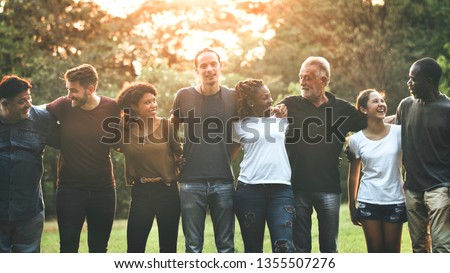 Photo of Cheerful diverse people huddling in the park